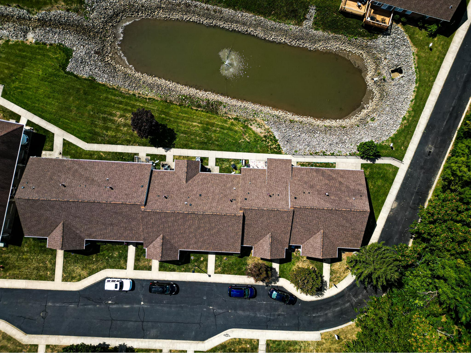 An aerial view of a residential area with a pond in the middle
