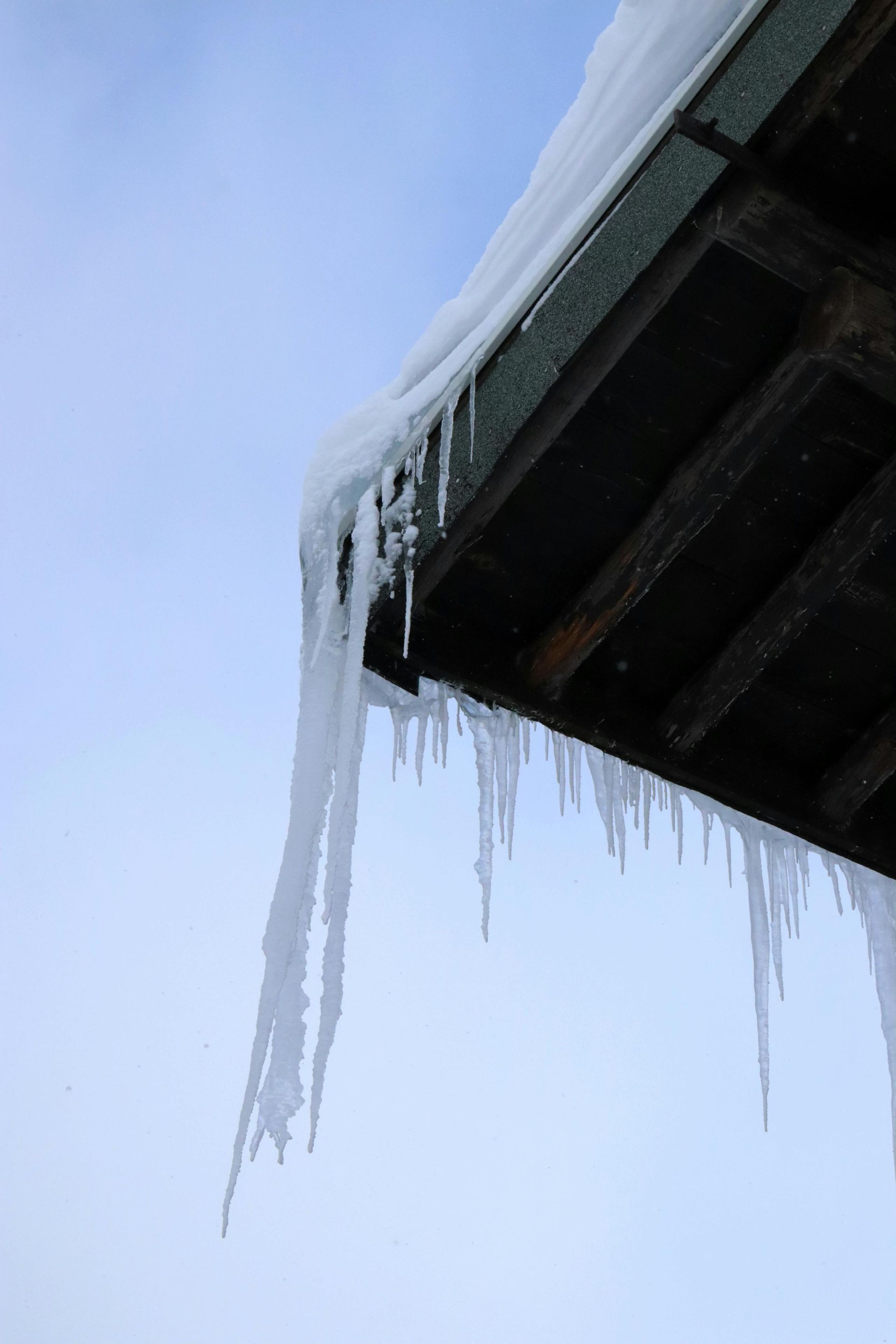 Icicles along a roof edge show the importance of ice dam prevention and winter roof protection