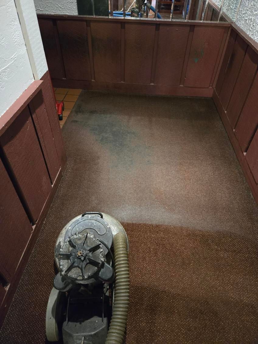 A vacuum cleaner is sitting on a dirty floor in a room.