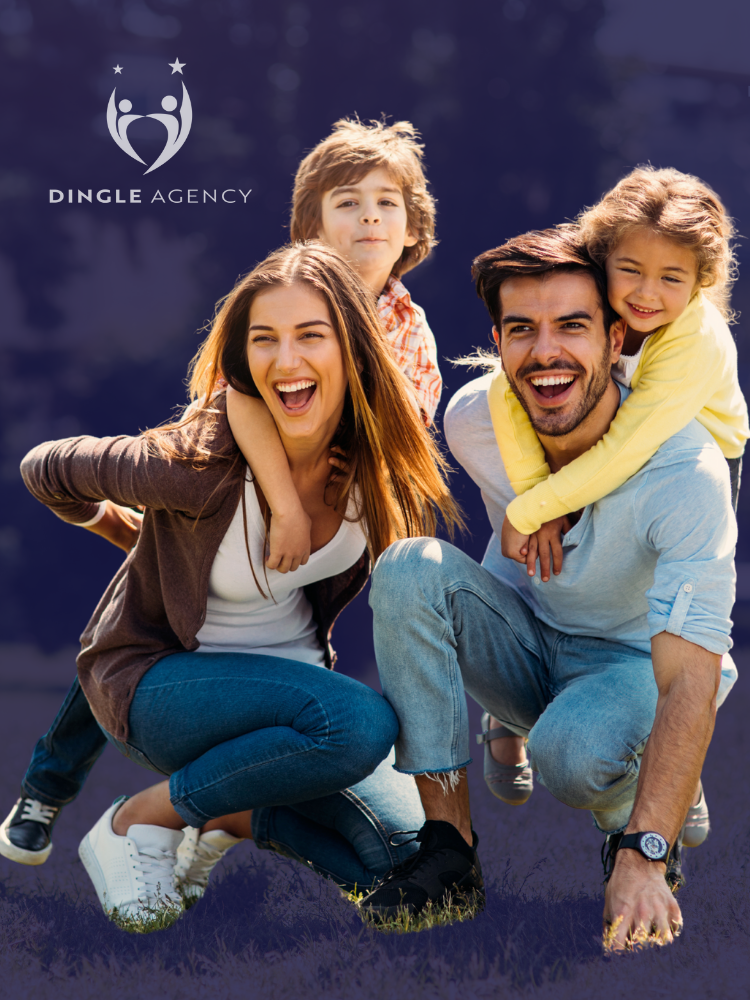 Smiling family of four posing outdoors on grass, with two children on parents’ backs near a mountain backdrop