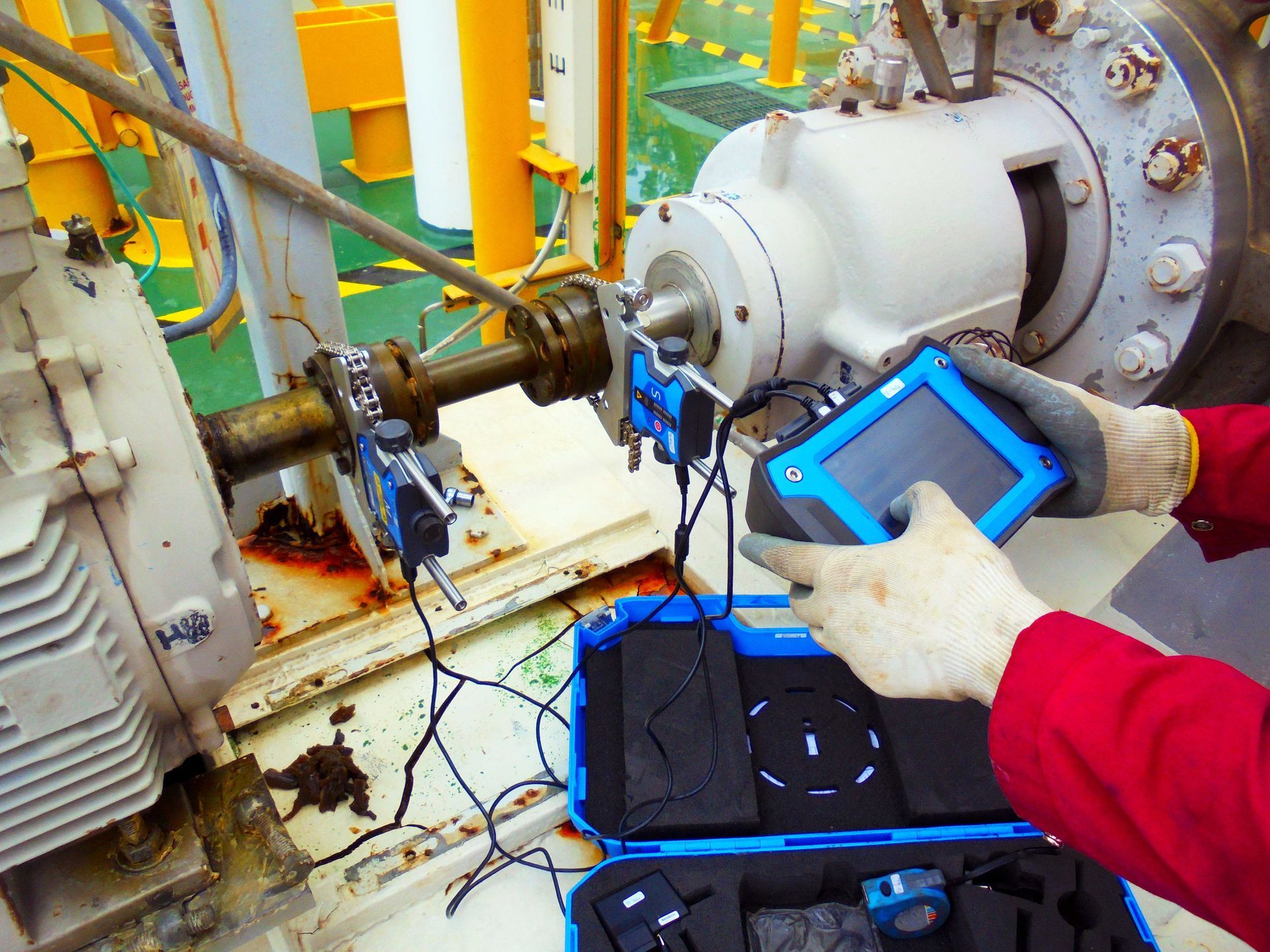 A person is working on a machine with a tablet in their hand