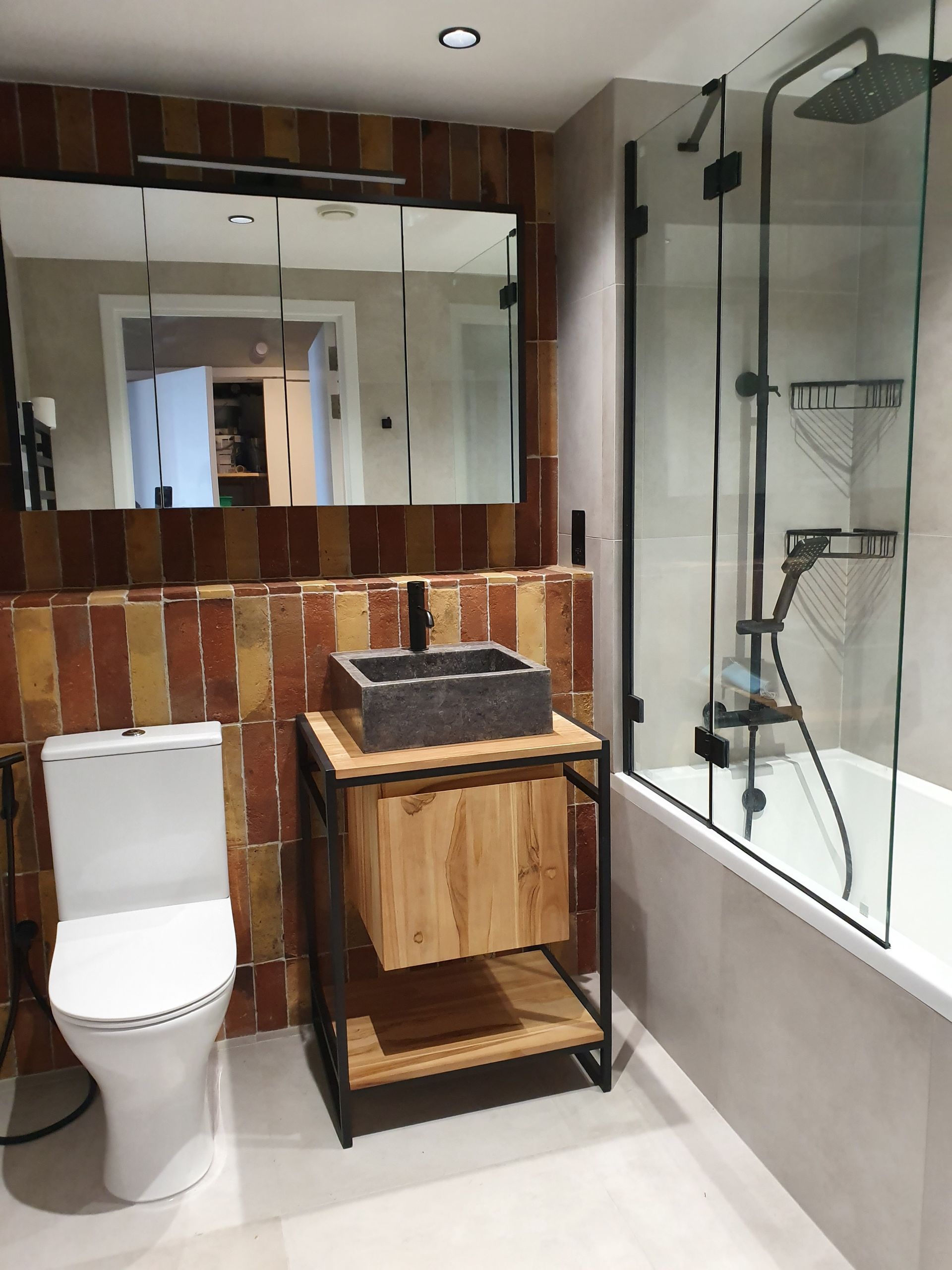 Spa-inspired bathroom with stone-basin vanity and matte-black fixtures