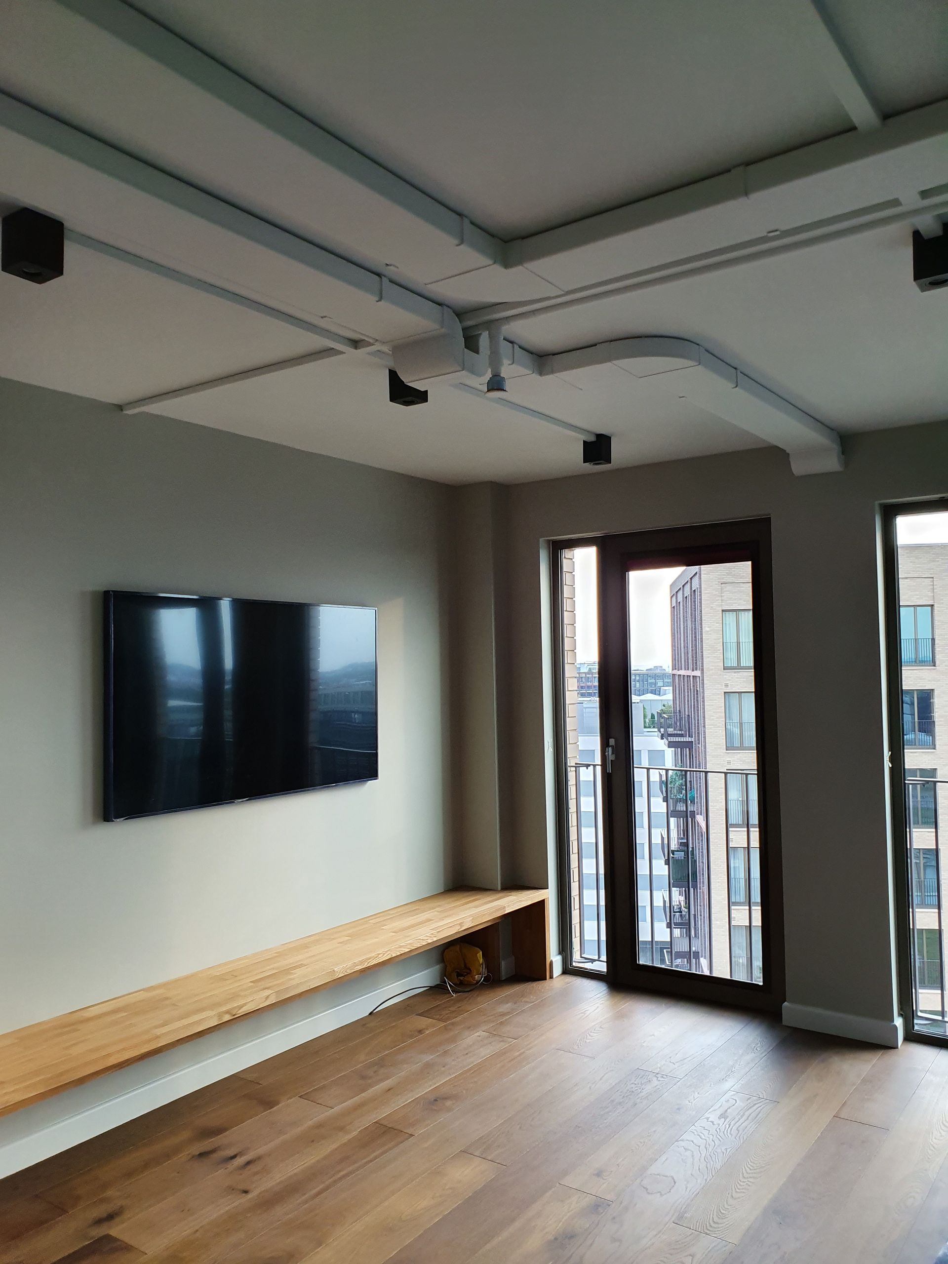 Industrial living room with exposed ceiling pipes and track lighting