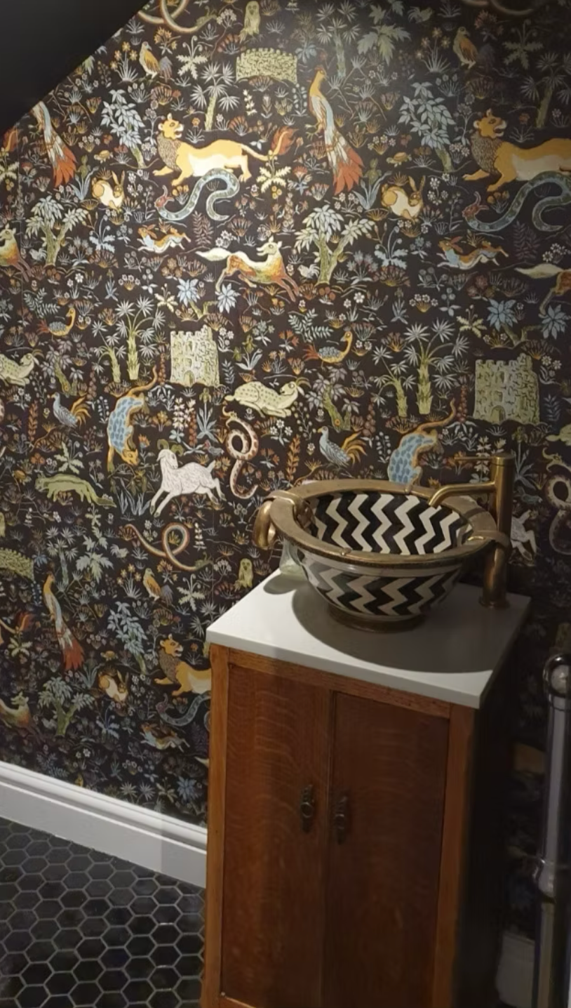 Detailed view of intricate patterned wallpaper featuring traditional animal and botanical illustrations