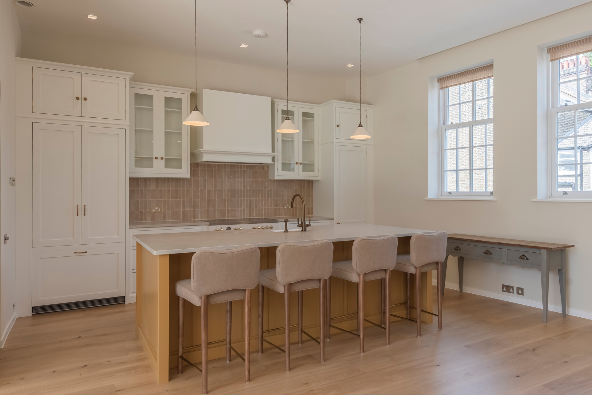 Bespoke modern kitchen with white classic cabinetry, a central island, and bar stools