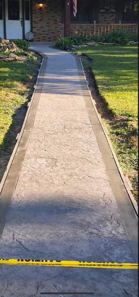 Concrete walkway leading to a house, bordered by grass. Yellow caution tape across path.