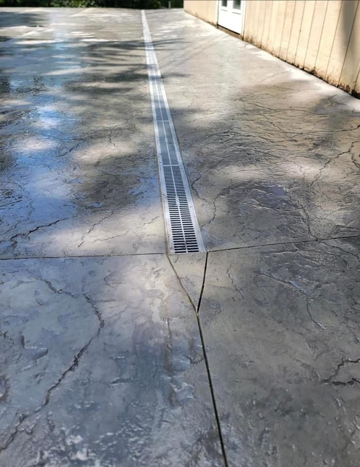 Gray concrete driveway with a central drainage system.