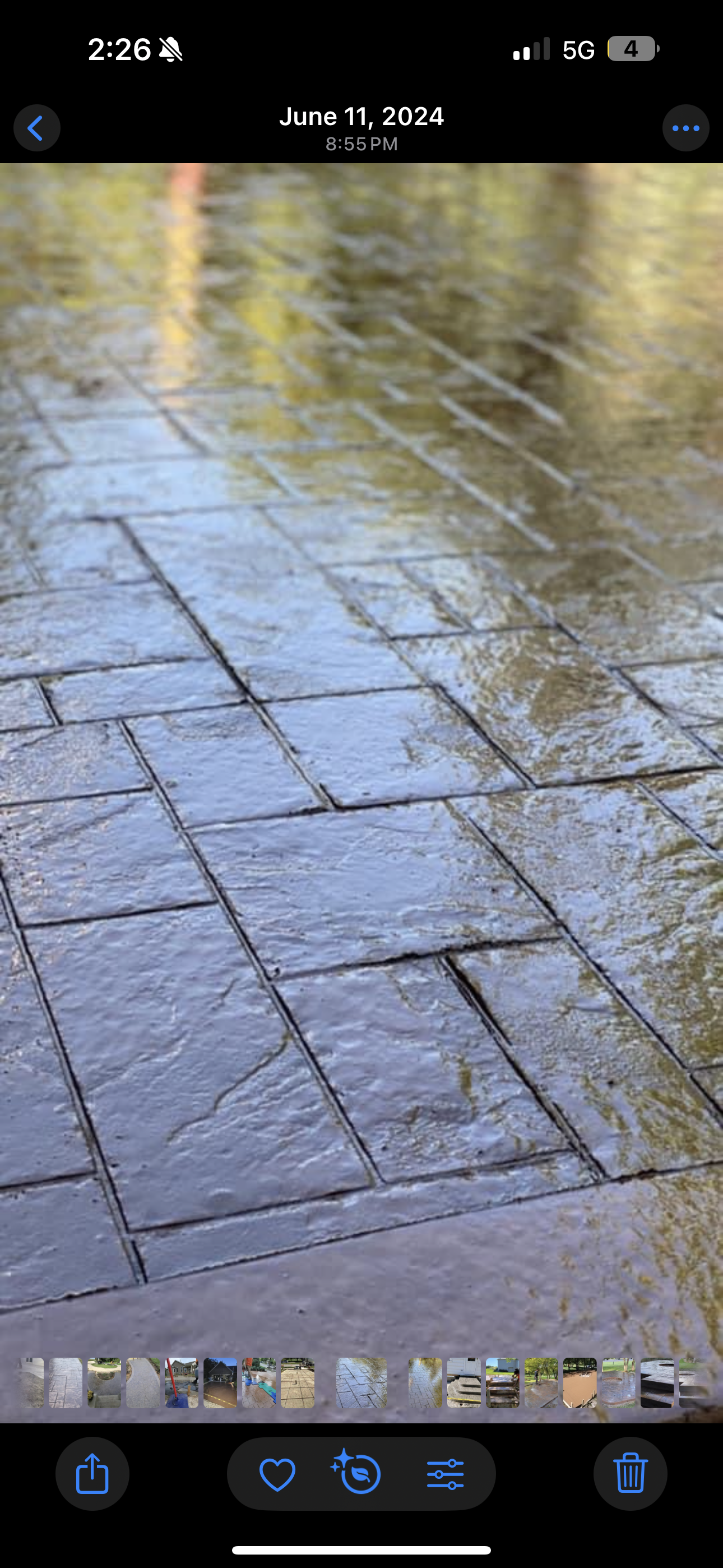 Wet, patterned stone walkway reflecting a blurry background.