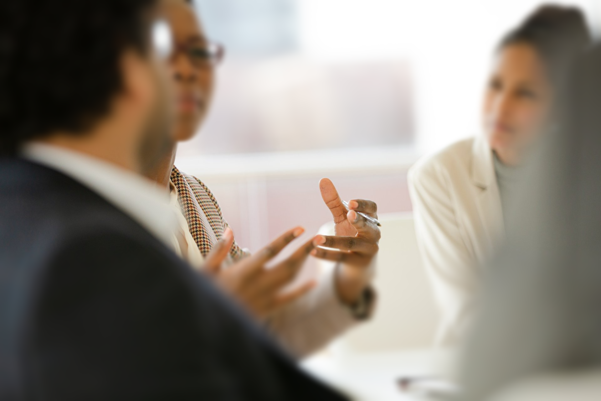 A group of people are sitting around a table having a conversation