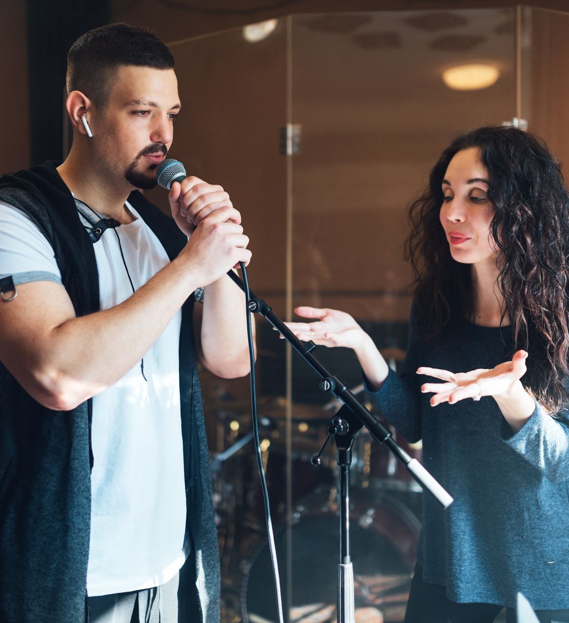 A man singing into a microphone next to a woman