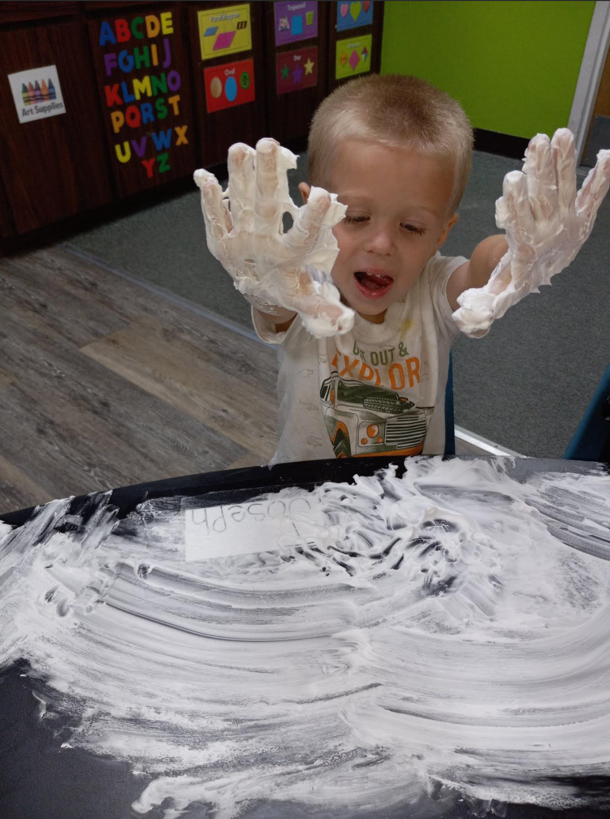A young boy is playing with foam on a table.