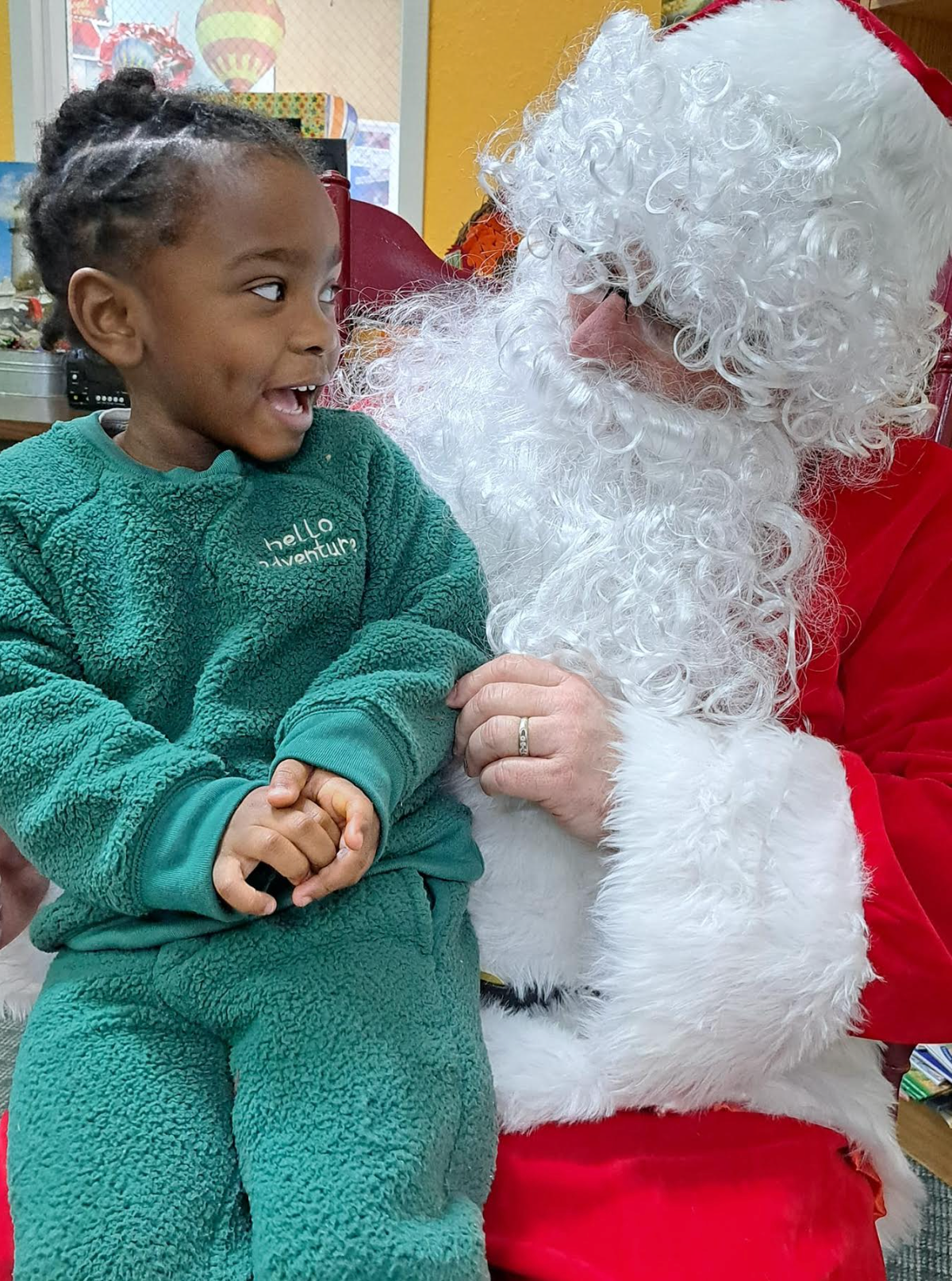 A little girl is sitting on santa 's lap.