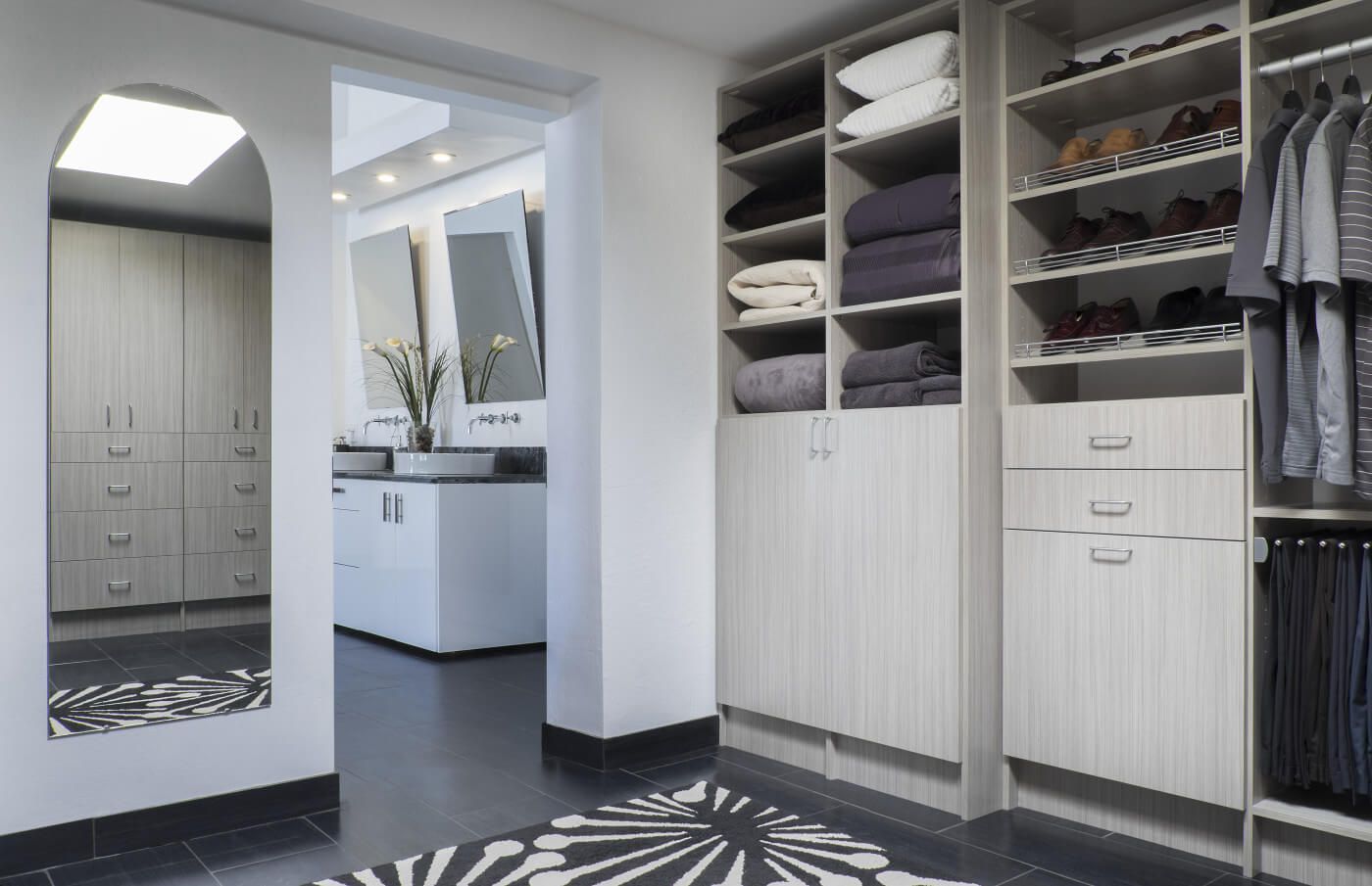 Spacious walk-in closet with large mirror and rug.