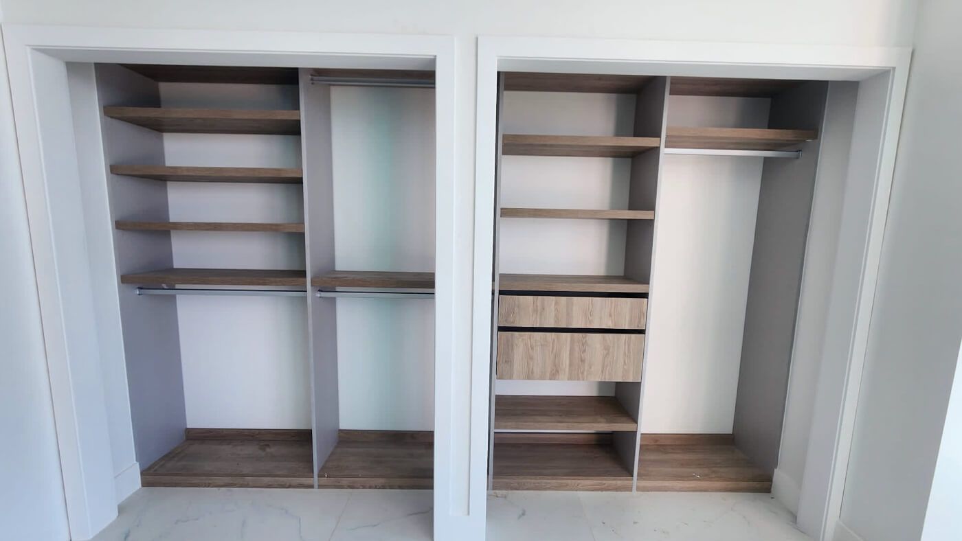 Functional reach-in closet featuring shelves and drawers