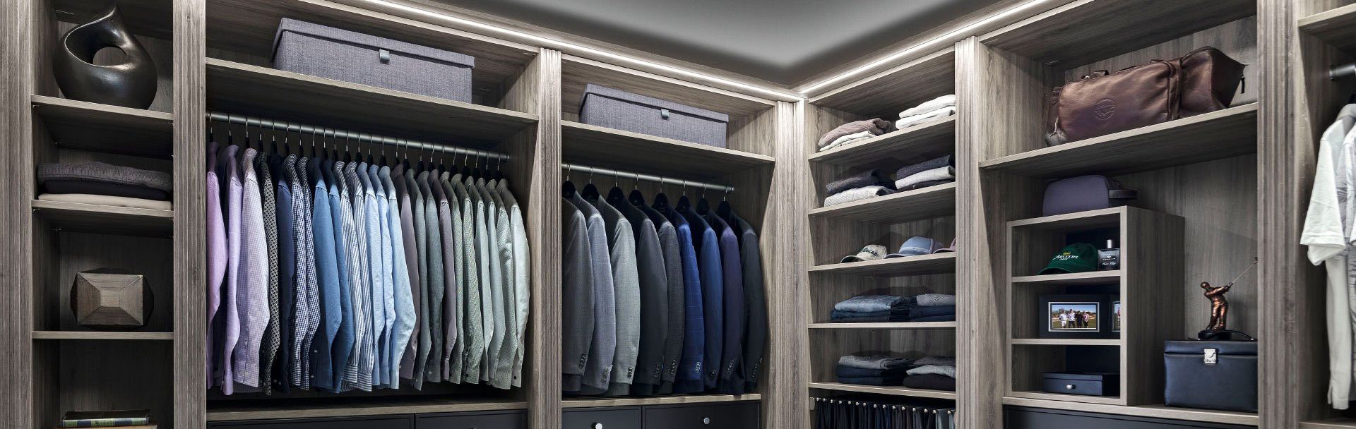 A walk in closet filled with lots of clothes and bags.