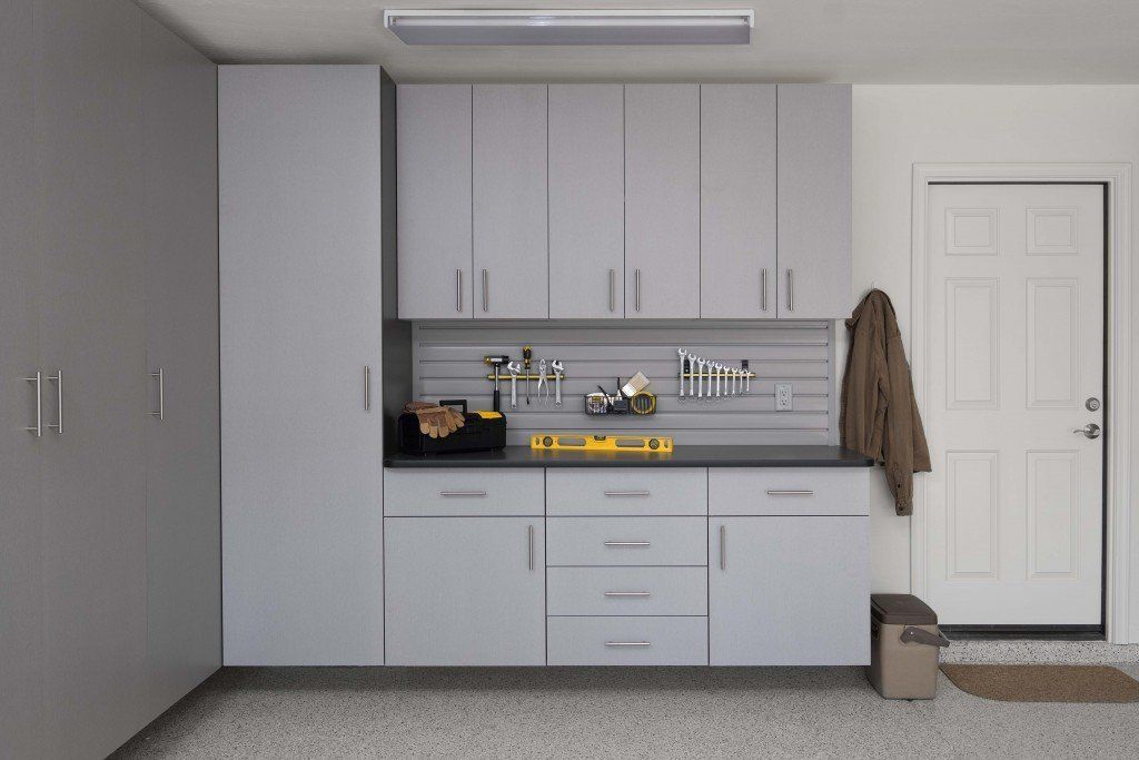 A garage with a lot of cabinets and drawers and a door.