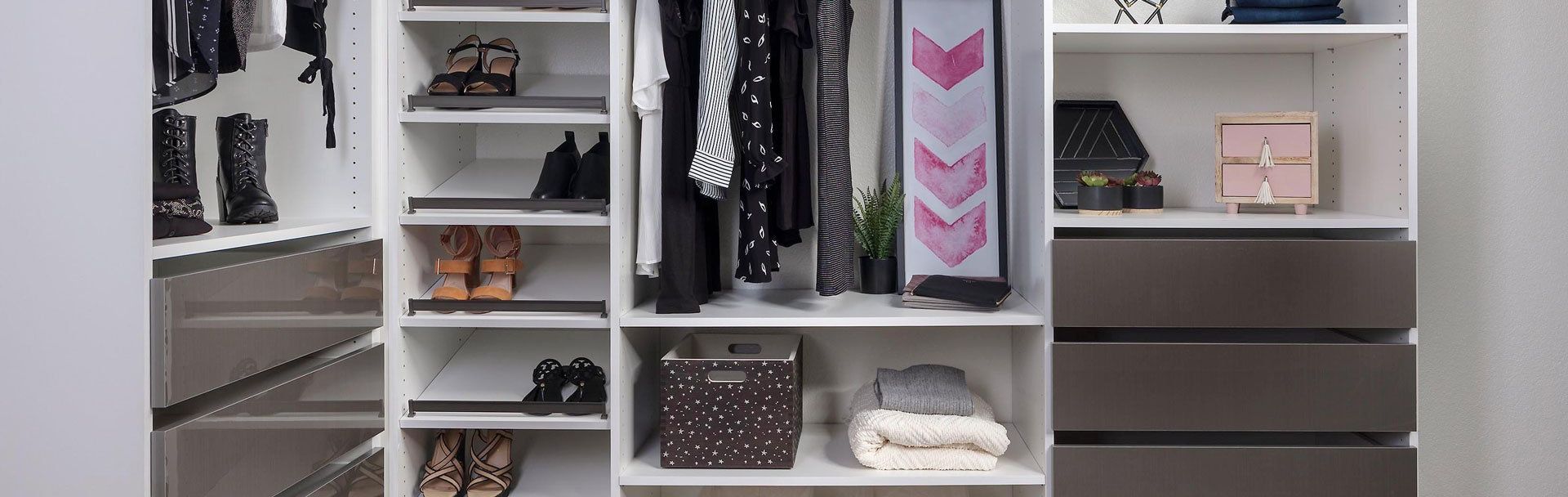 A walk in closet filled with lots of clothes and shoes.