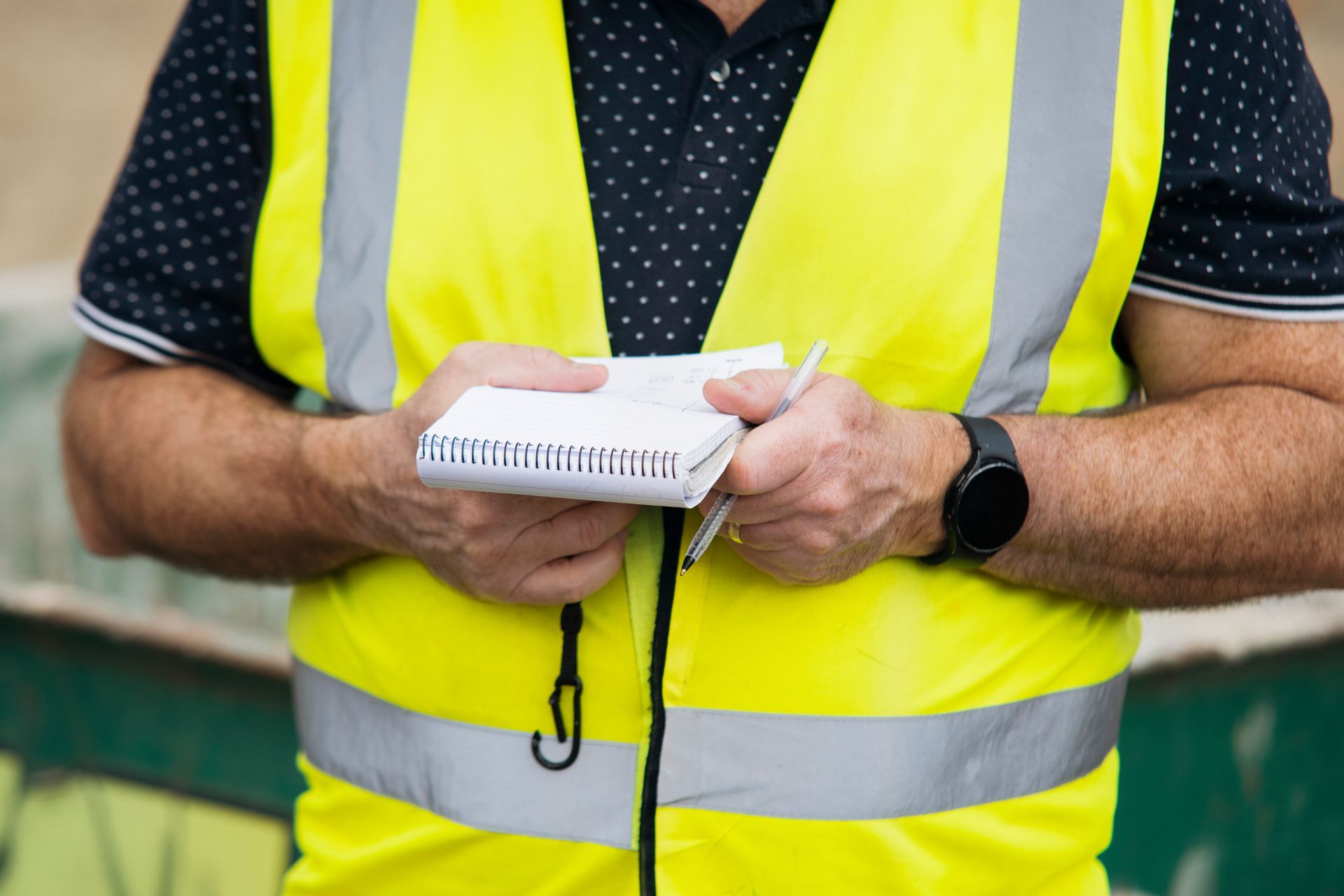 A man is holding a notepad.