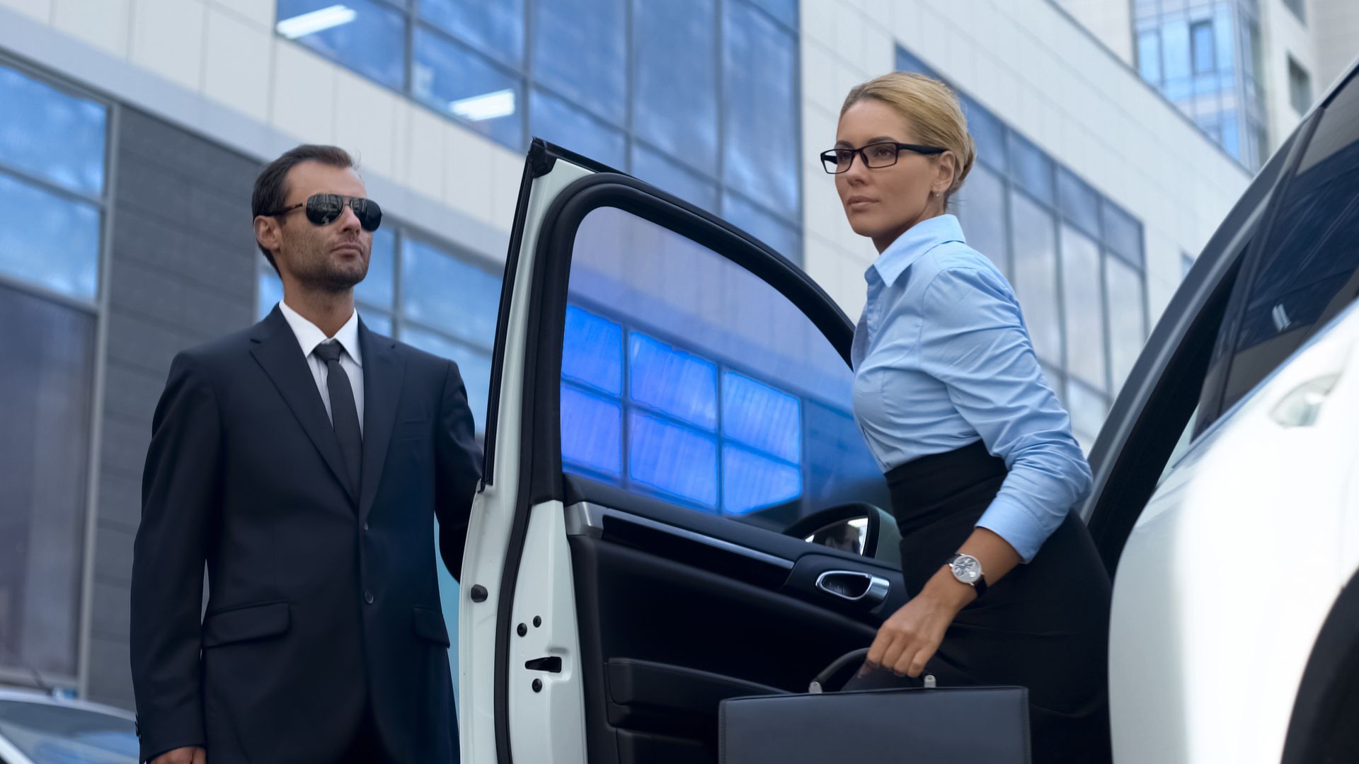 A man and a woman are getting out of a limousine.
