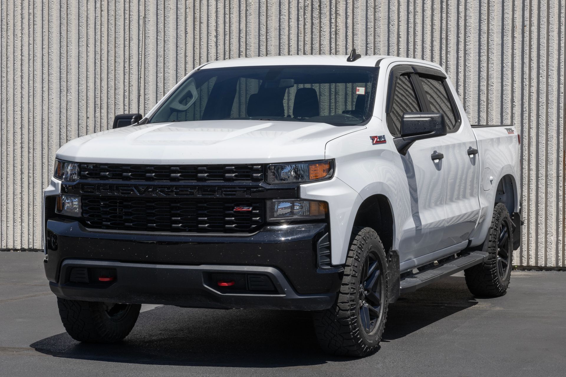 A white truck is parked in front of a building.