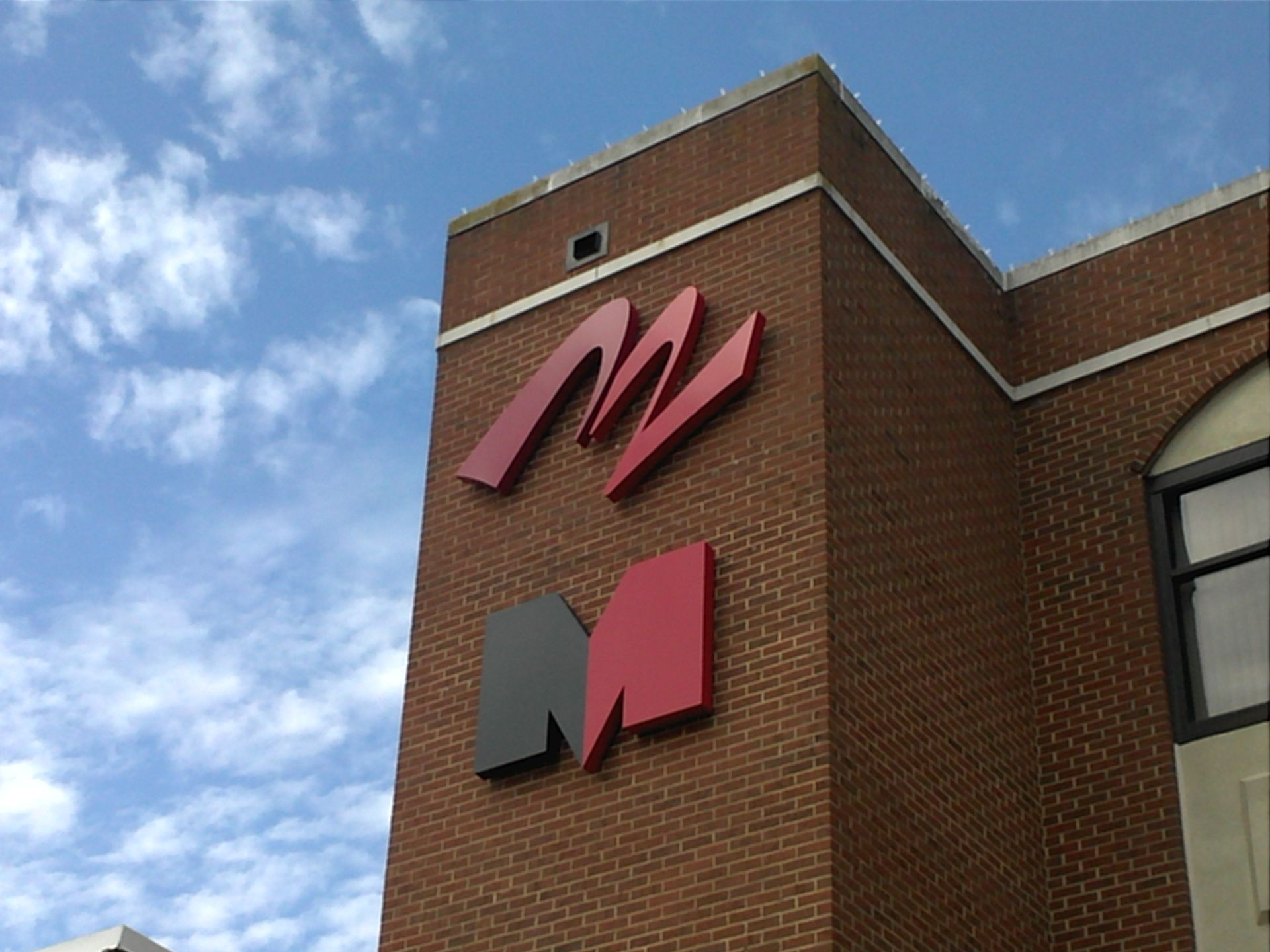 A red and black sign on the side of a brick building