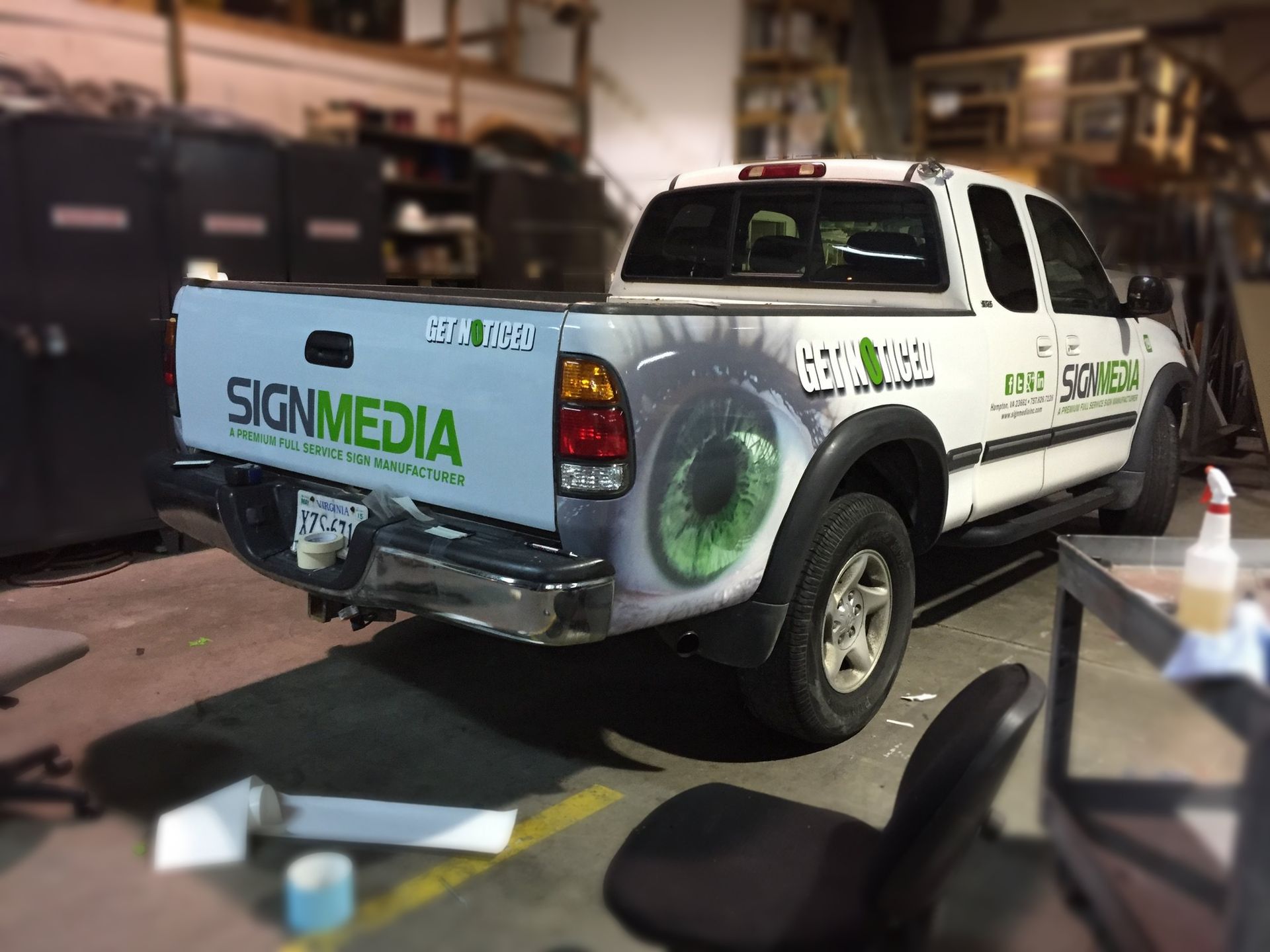 A white truck with the word signmedia on the back