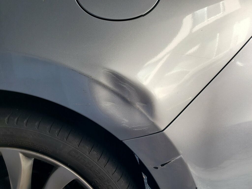 Fender dent before paintless dent repair