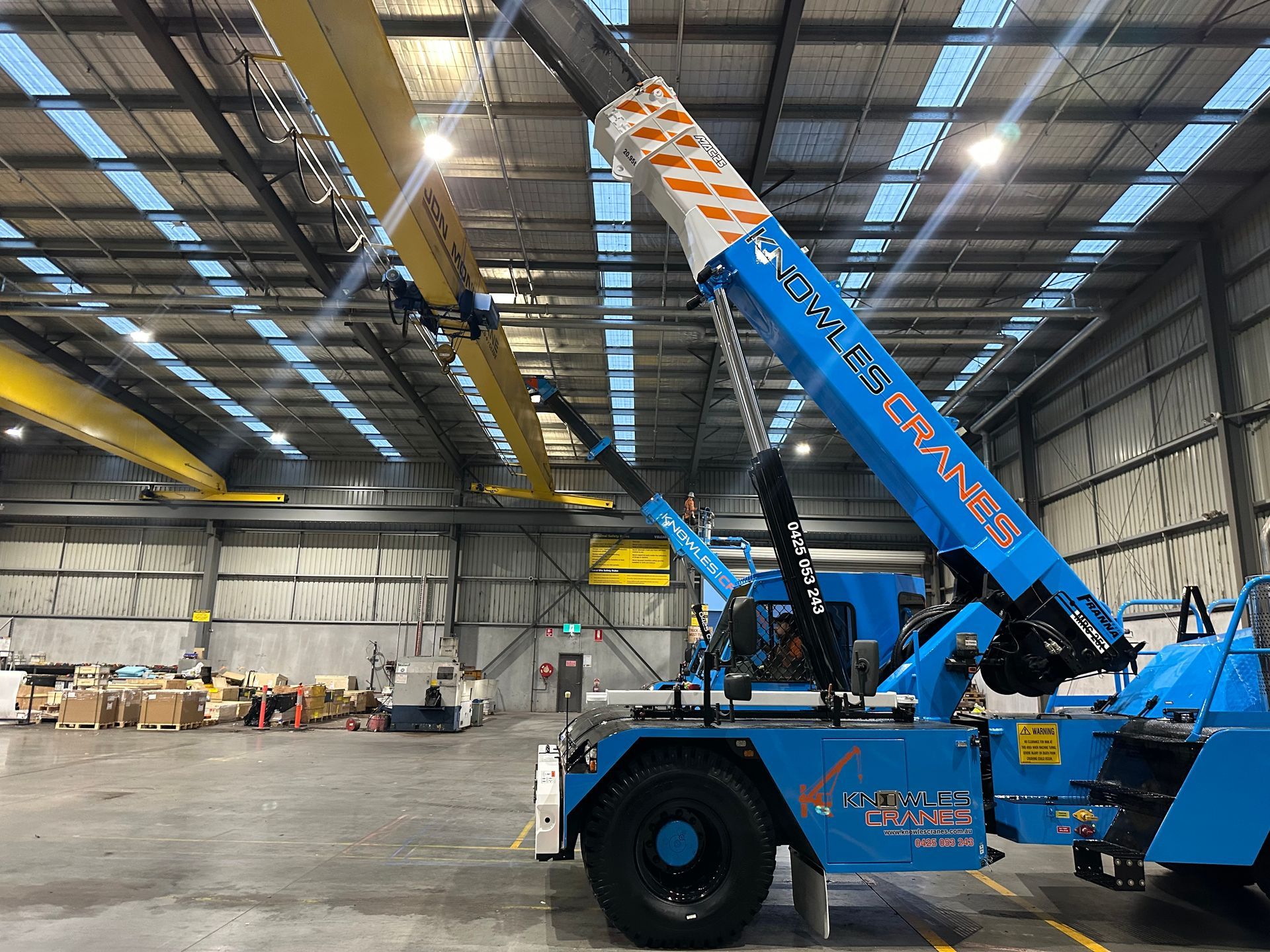 Precision lifting indoors with Knowles Cranes installing overhead beams safely and smoothly in tight warehouse space.