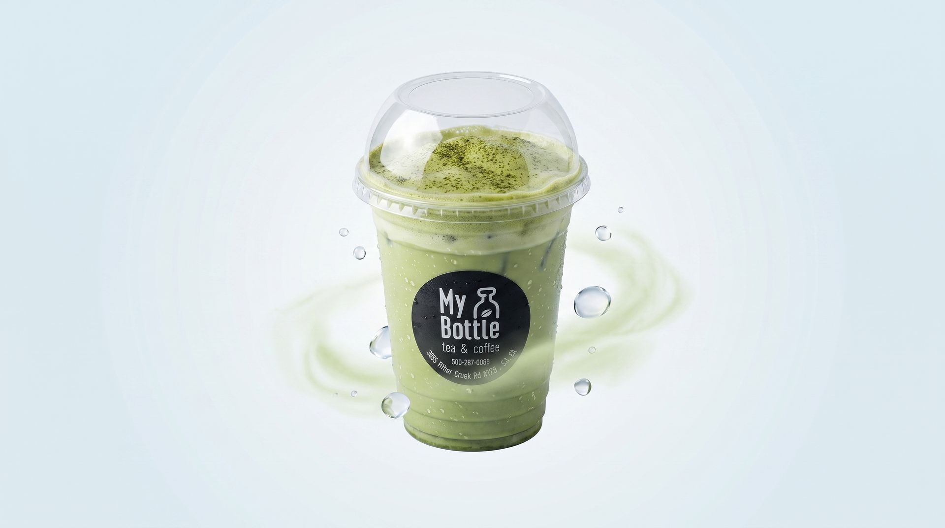 Iced green drink in a clear domed cup with a black label on a white background