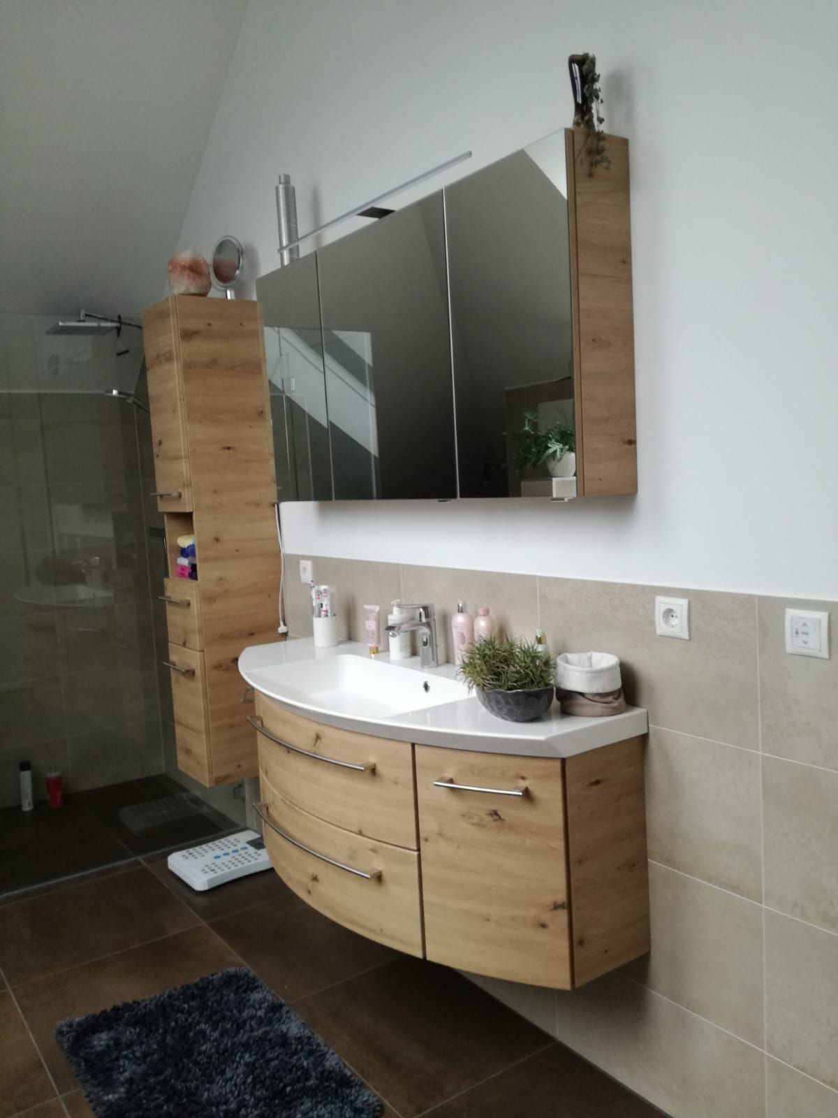 Ein Badezimmer mit Waschbecken und Spiegel und Fliesen an Boden und Wand