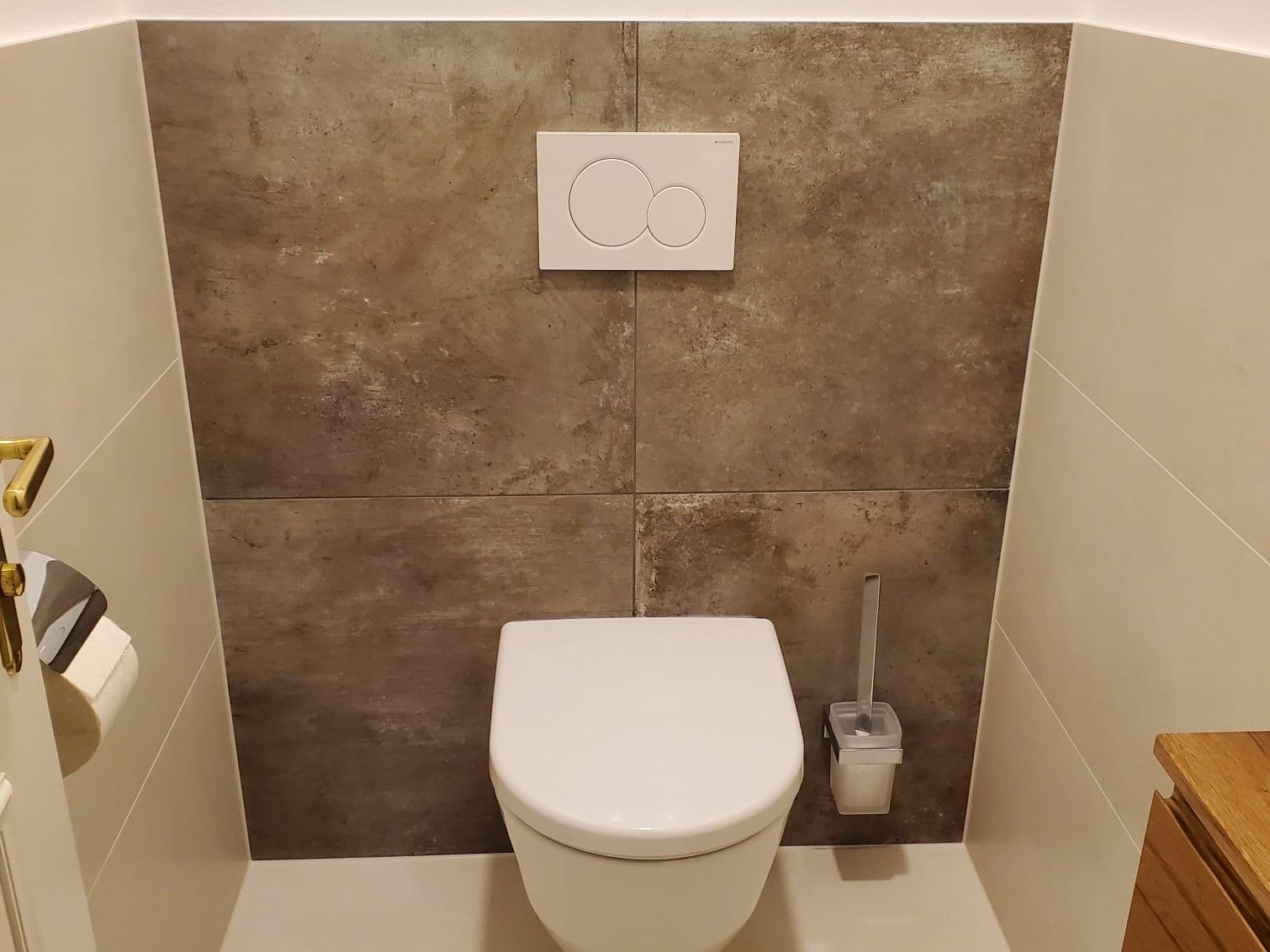 Ein Badezimmer mit Toilette und Bürste an der Wand.
