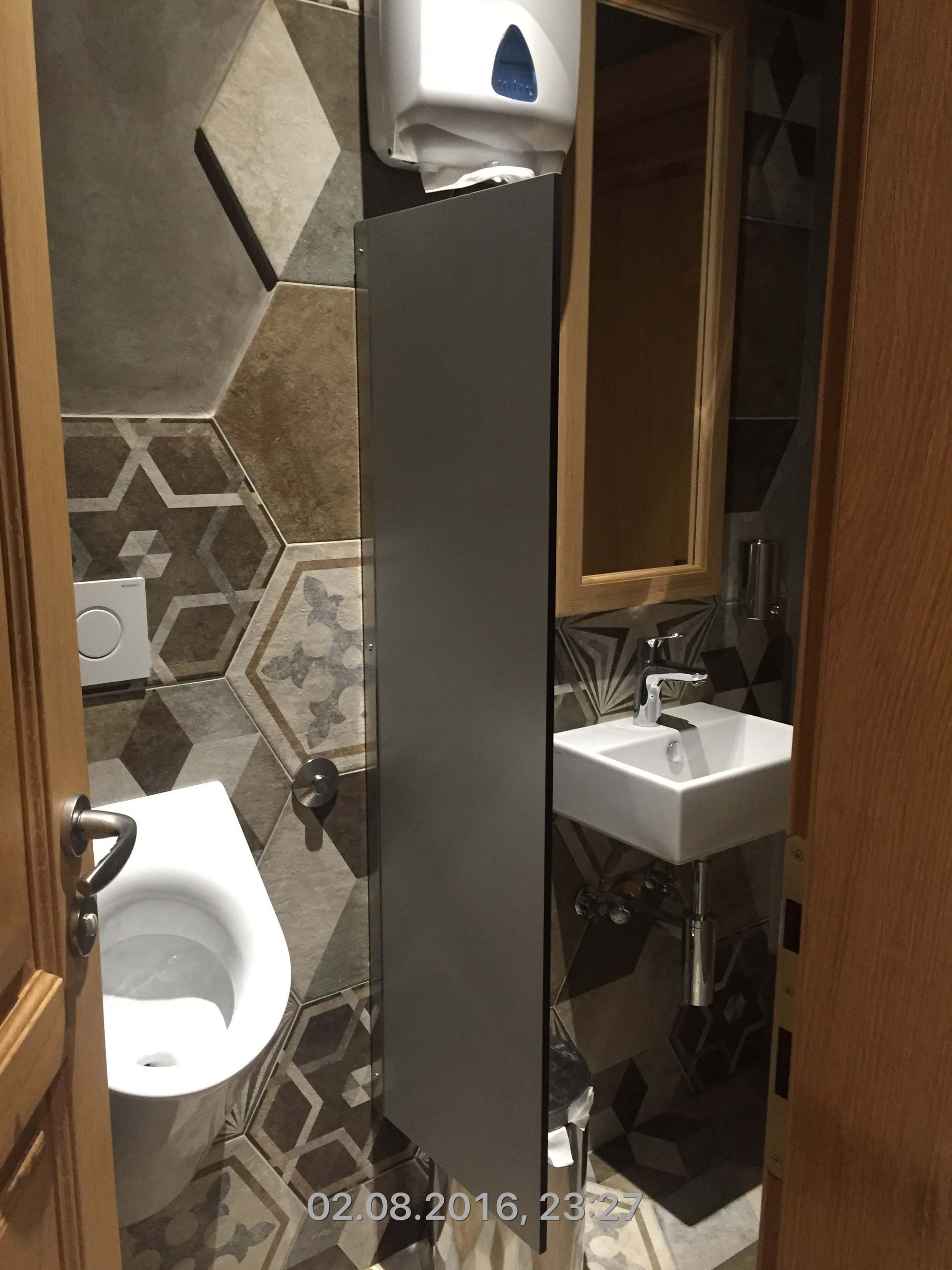 Ein Badezimmer mit Toilette, Waschbecken und Spiegel