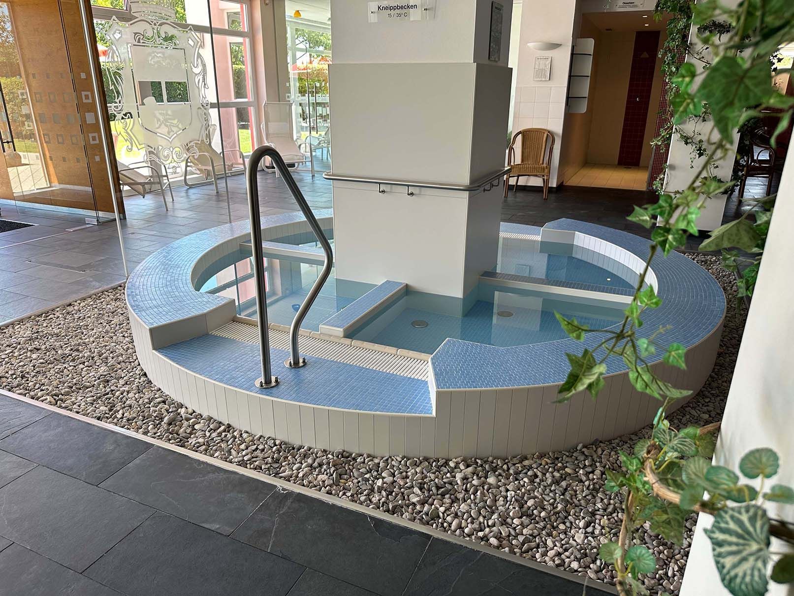 Ein runder Pool mit einer Treppe, die in einem Gebäude hineinführt.