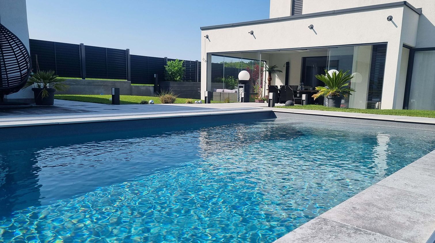 Vor einem Haus befindet sich ein großer Swimmingpool.