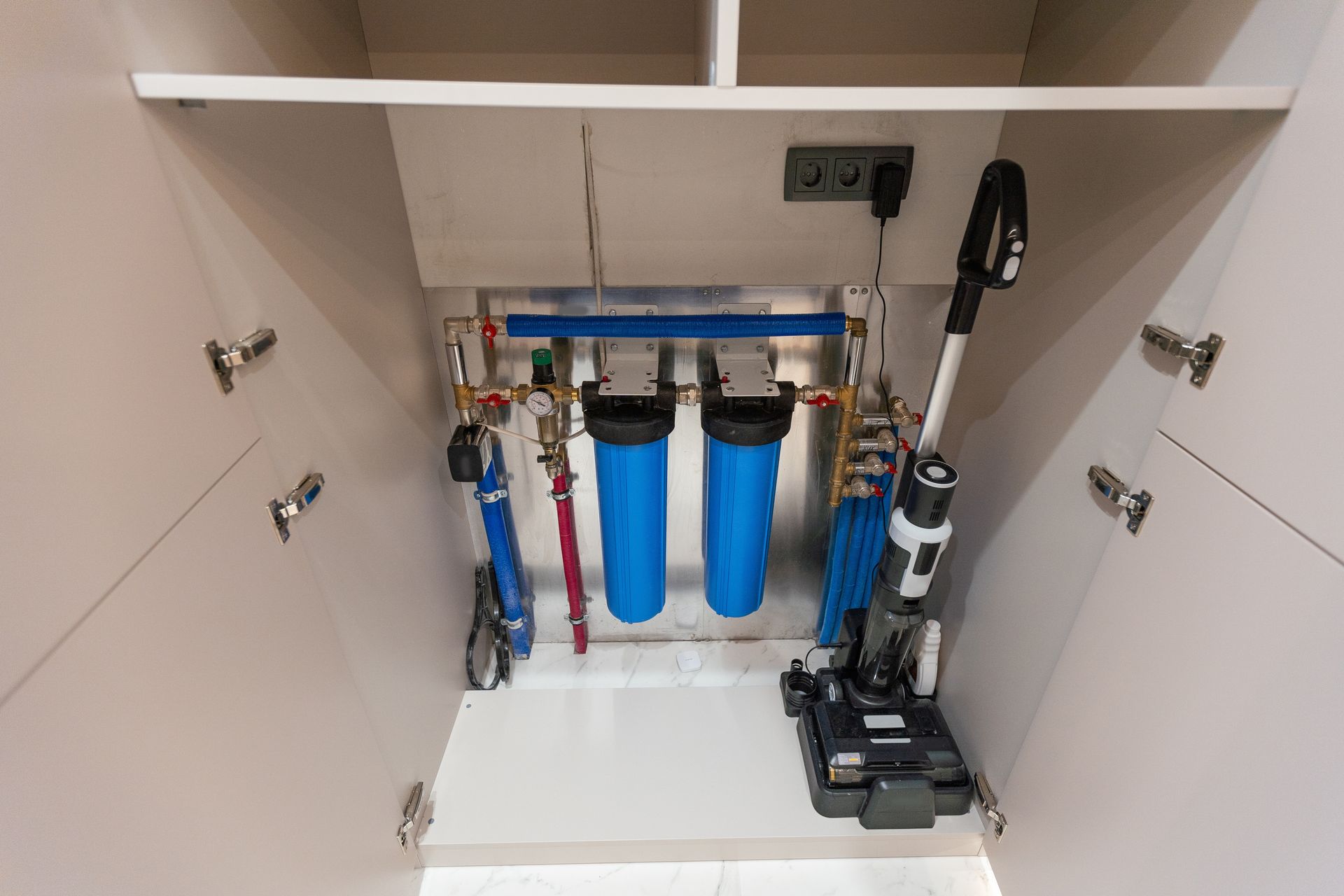 A vacuum cleaner is sitting under a water filter in a cabinet in Atlanta, GA