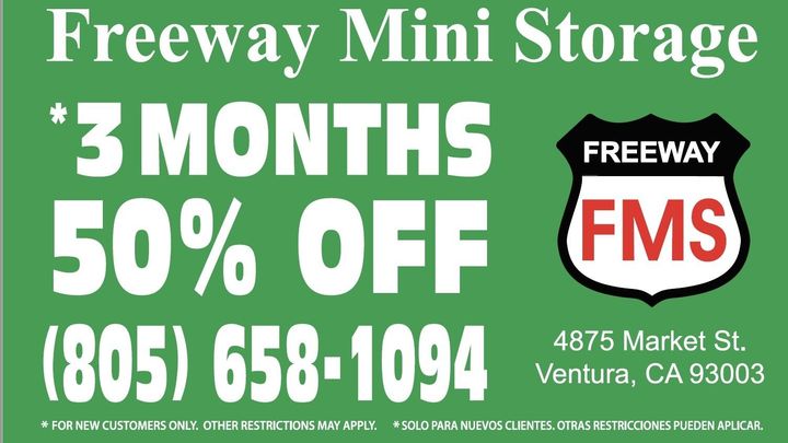 A green sign that says ' freeway mini storage ' on it
