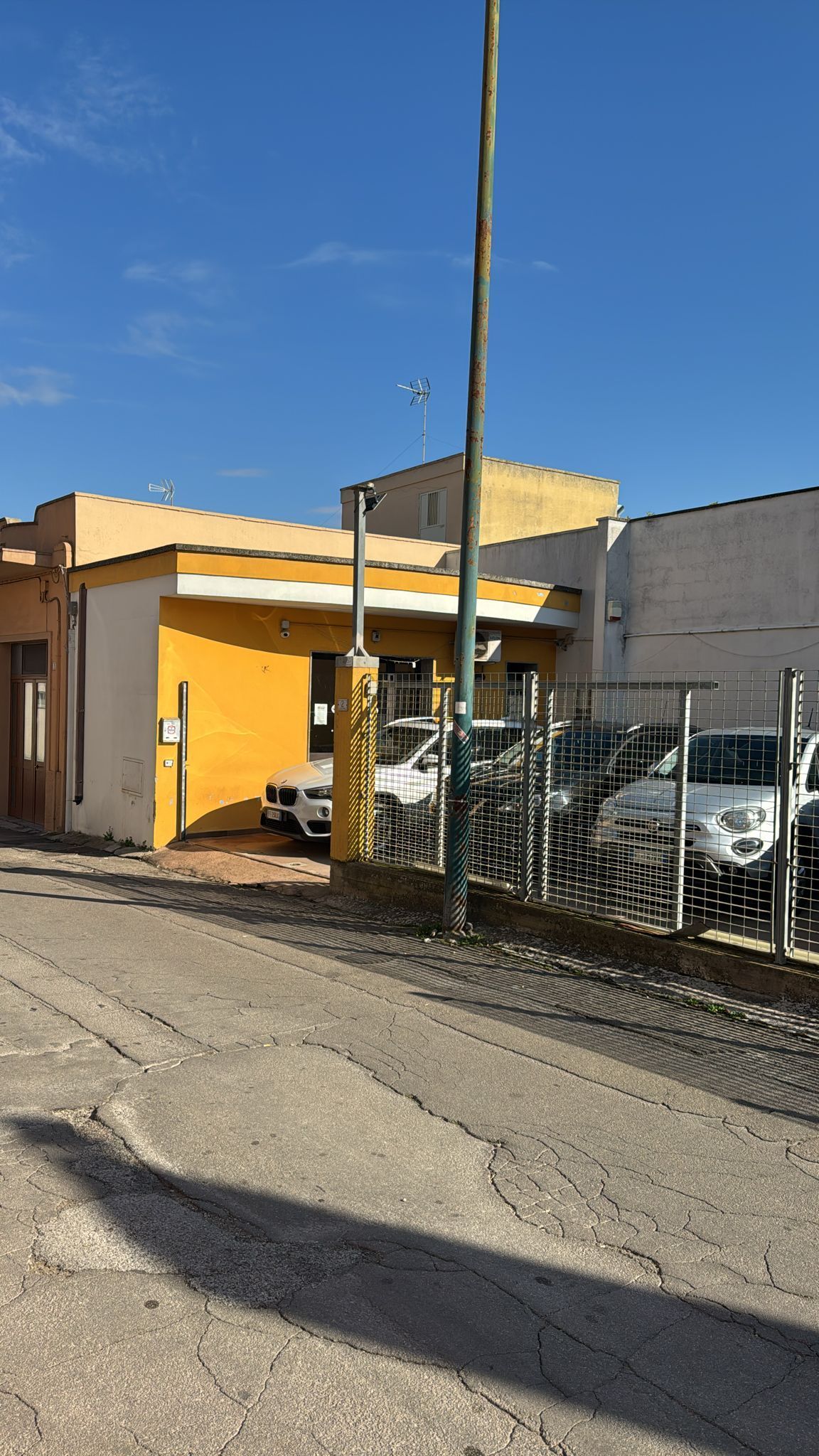 un'auto nera è parcheggiata sul lato di una strada vicino all'oceano al tramonto.