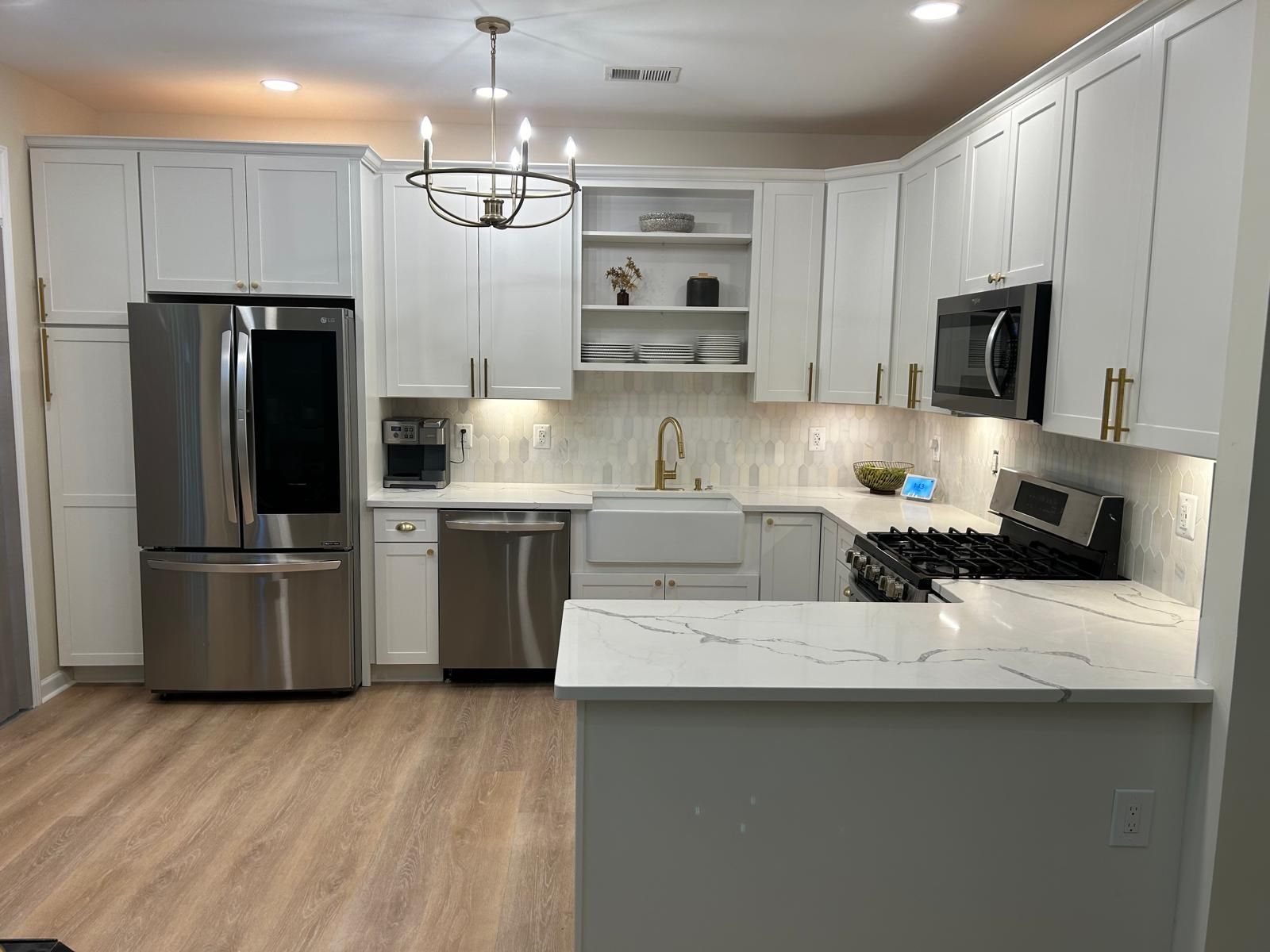 Monroe NJ kitchen renovation with stainless steel appliances, white cabinets, and light wood floors