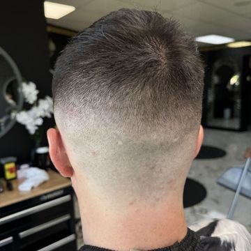 A man is getting his hair cut in a barber shop.