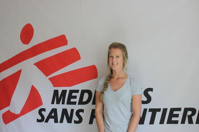 Woman standing in front of a Médecins Sans Frontières banner