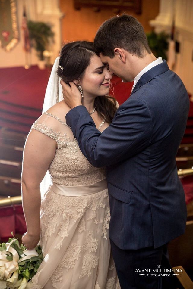A bride and groom are posing for a picture in a church.