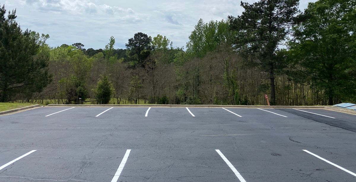 Patch damaged asphalt, sealcoating, and line striping parking lot in Ruston Louisiana
