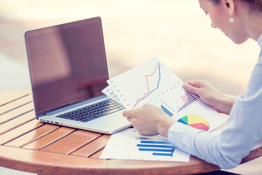 Woman Analyzes Financial Charts While Using a Laptop — Precision Financial & Tax In Ross Creek, VIC