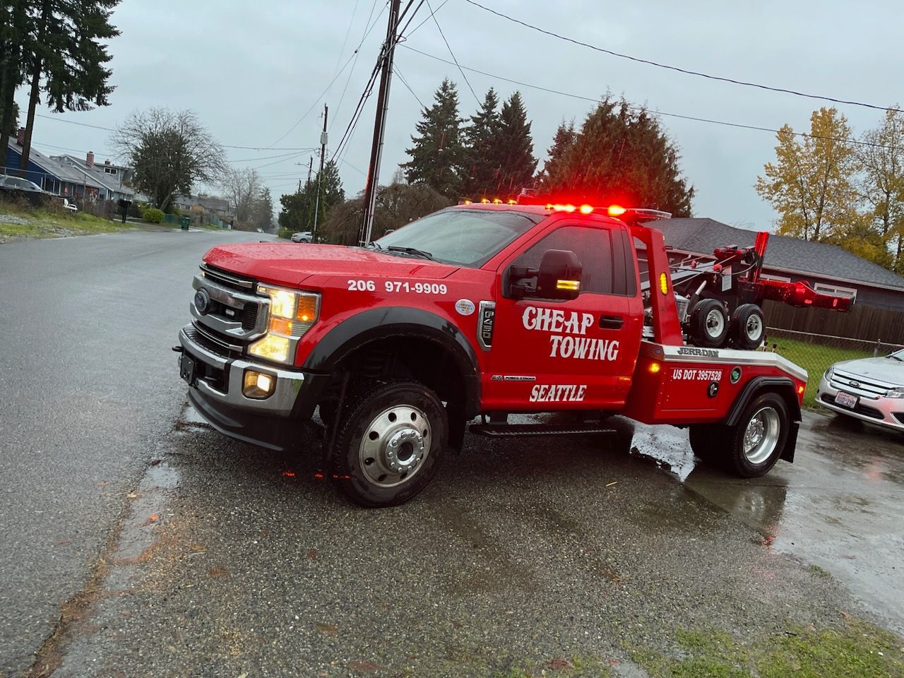 A red tow truck is parked on the side of the road.