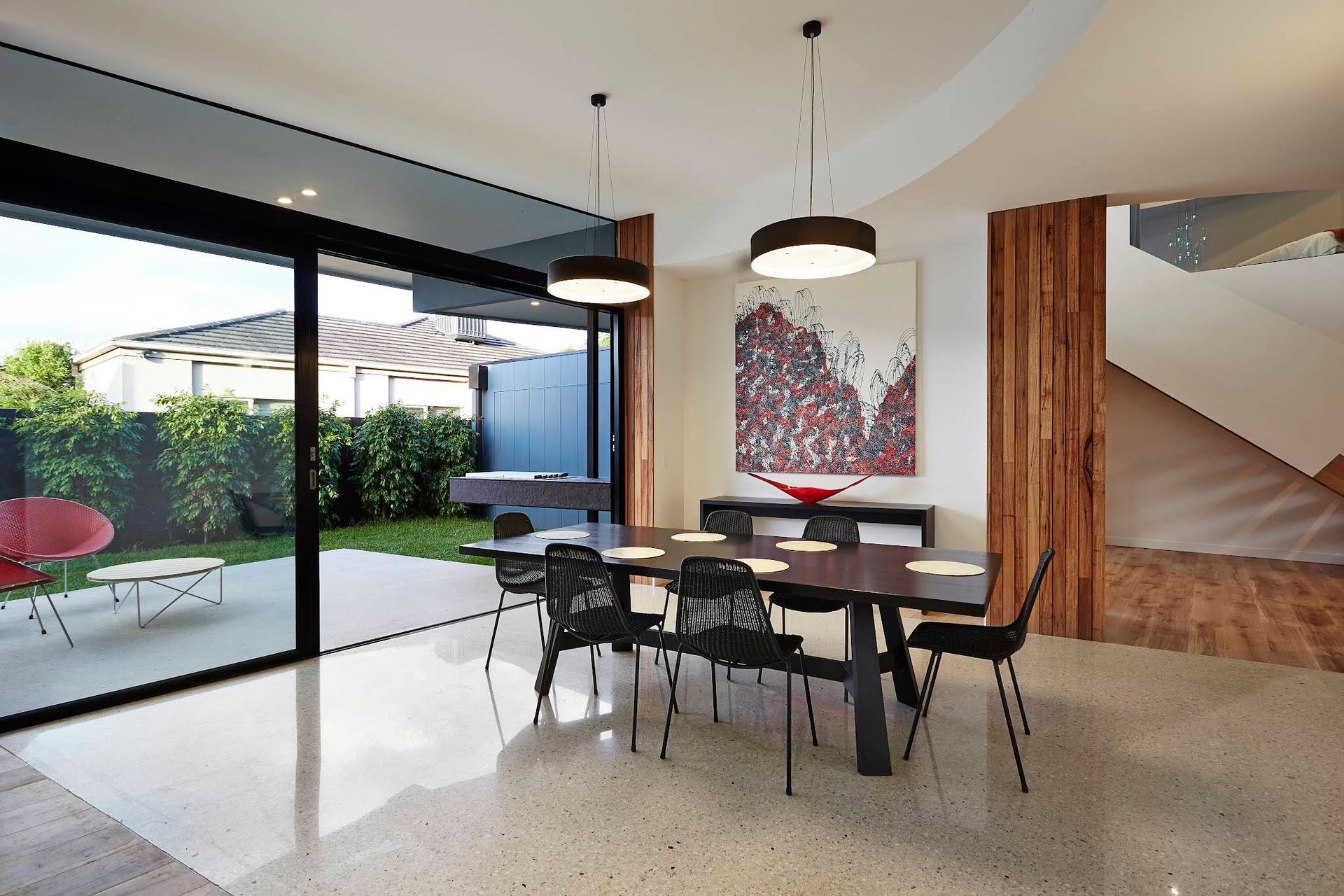 Modern Dining Area With Black Chairs and Sliding Glass Doors to a Patio — KM Custom Homes In Mount Eliza, VIC