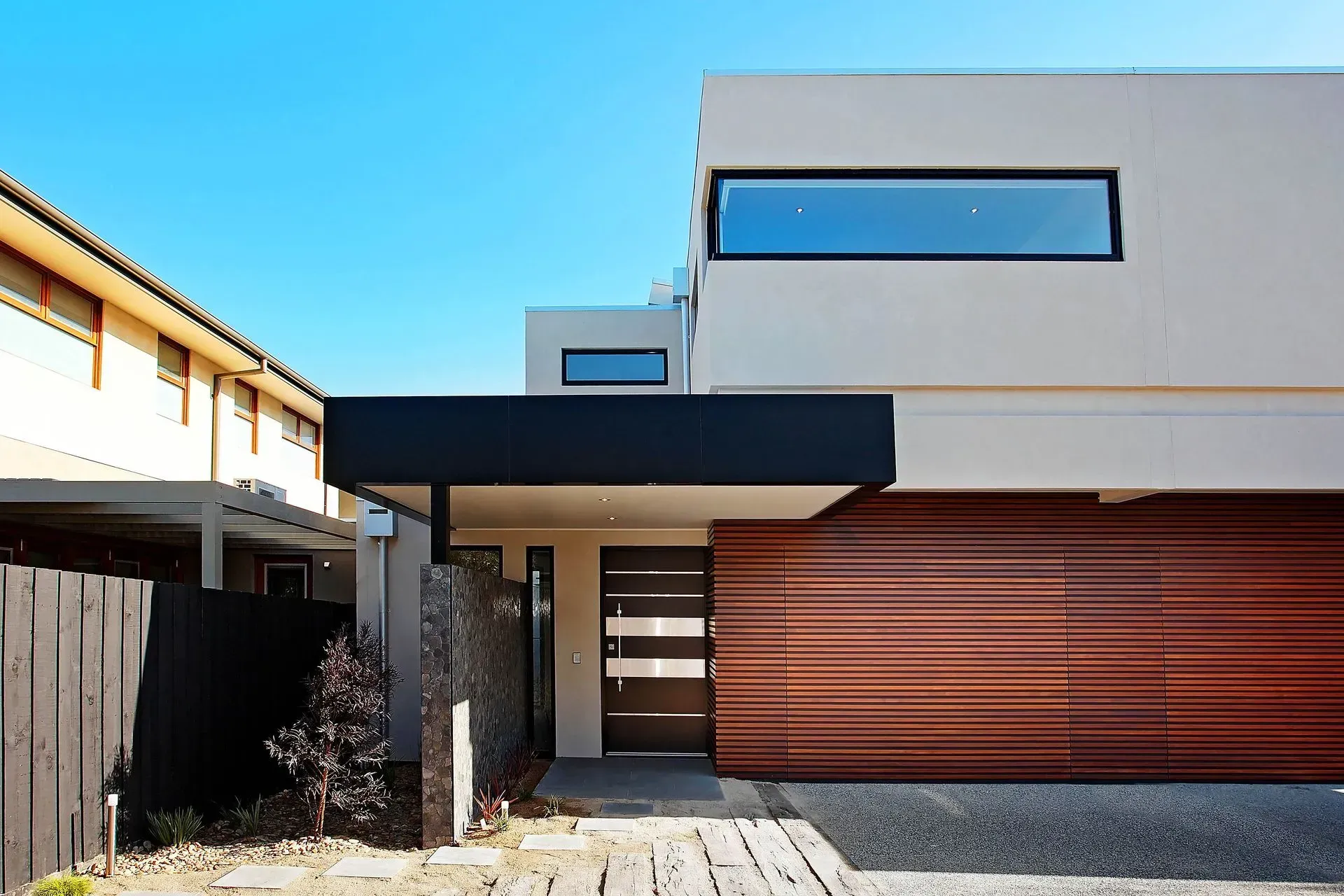 Modern House Exterior With Wood Garage Door — KM Custom Homes In Mount Eliza, VIC