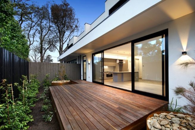 A House With A Wooden Deck And Sliding Glass Doors — KM Custom Homes In Rosebud, VIC