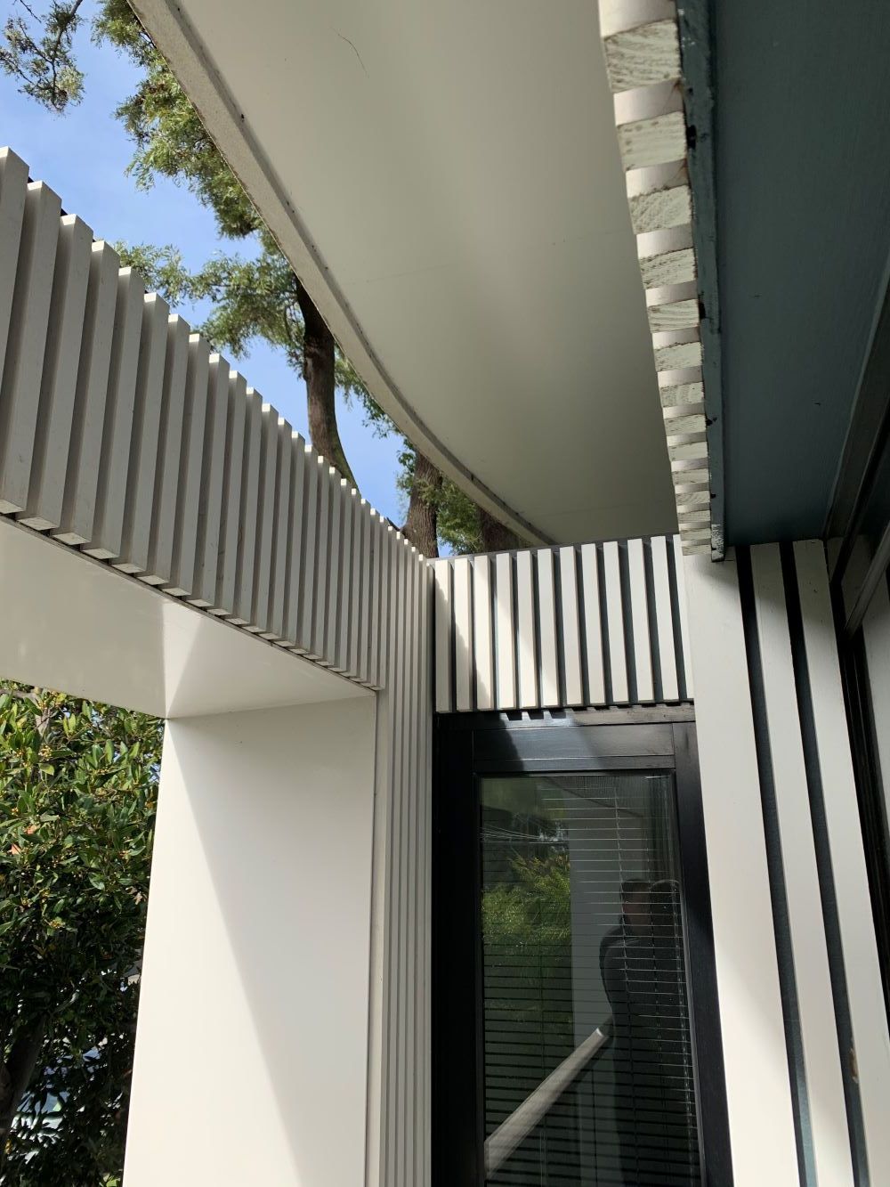 A White Building With A Black Door And A White Roof — KM Custom Homes In Rosebud, VIC