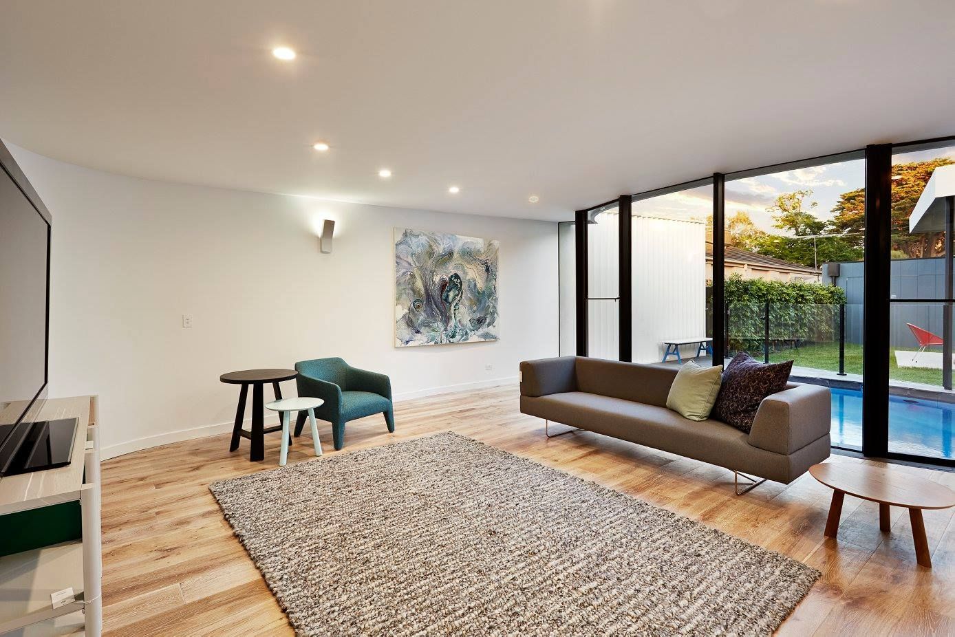 Bright Modern Living Room With Sofa, Rug And Glass Doors — KM Custom Homes In Mount Eliza, VIC
