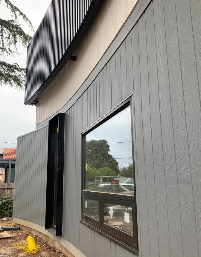 Modern Gray Building Exterior With Dark Trim And A Large Window — KM Custom Homes In Rosebud, VIC